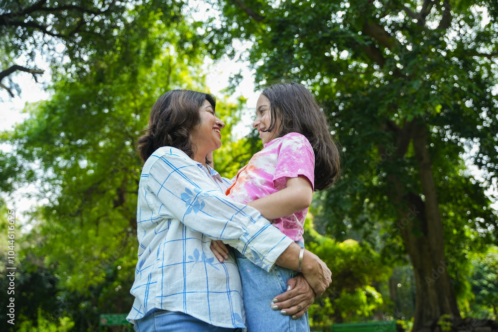 Young indian mother carrying, holding her daughter on shoulder spending time together. bonding , playful interaction , holiday, vacation concept. Young indian mother carrying, holding her daughter on shoulder spending time together. bonding , playful interaction , holiday, vacation concept.