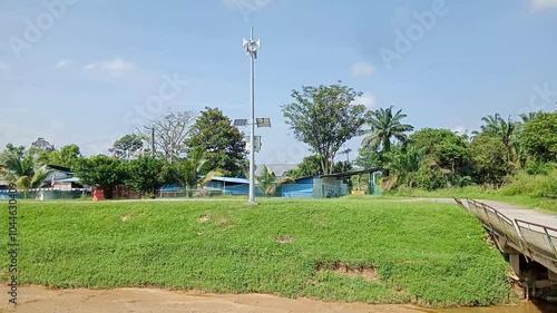 Solar powered flood alert siren pole with blue sky and white cloud background in the countryside.photo taken in kluang, johor, malaysia photo