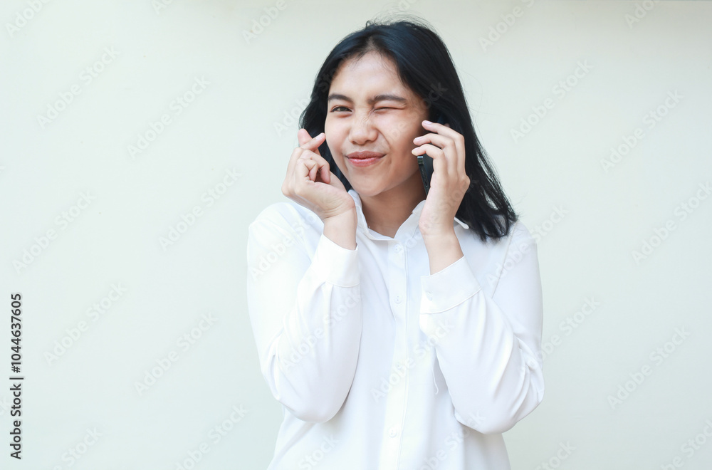 delighted asian business woman showing korean love signs and blink eye flirting at camera while speaking on smartphone wearing white formal suit shirt, heart shape symbols, standing isolated delighted asian business woman showing korean love signs and blink eye flirting at camera while speaking on smartphone wearing white formal suit shirt, heart shape symbols, standing isolated