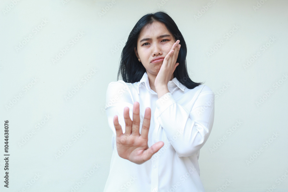 portrait of sad tired asian business woman wearing white shirt formal suit reaching hands towards camera showing stop signs and leaning face on palms standing isolated background portrait of sad tired asian business woman wearing white shirt formal suit reaching hands towards camera showing stop signs and leaning face on palms standing isolated background