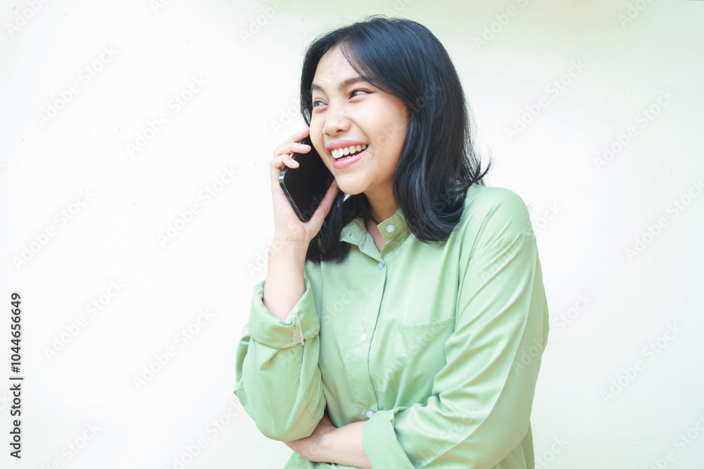 ecstatic successful asian woman wearing green oversize shirt talking on smartphone laughing of funny conversation standing over siolated white background ecstatic successful asian woman wearing green oversize shirt talking on smartphone laughing of funny conversation standing over siolated white background