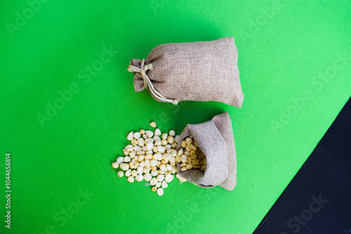 Dry corn seeds bag. Prepare to make corn flour. Native agriculture in countryside concept, A close-up pile of organic Corn Seeds (Zea mays) or Makka, isolated on a green  background. Top view, jawar