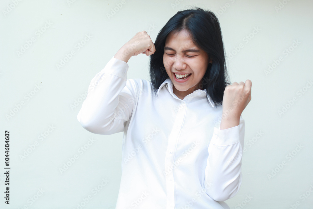 successful asian business woman rejoicing victory by raising fist showing yes gesture with closed eyes wearing white shirt formal suit, celebrating champion winner, isolated on white background successful asian business woman rejoicing victory by raising fist showing yes gesture with closed eyes wearing white shirt formal suit, celebrating champion winner, isolated on white background