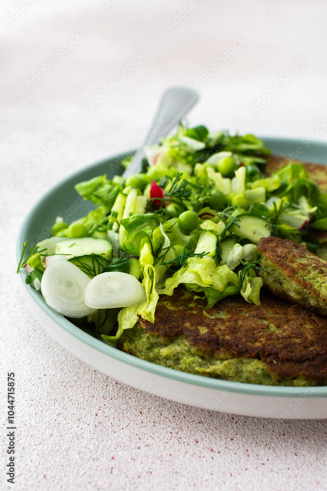 Zucchini and broccoli pancakes served with a mixed salad of cucumbers, young peas, and radishes. This healthy vegetarian dish is both delicious and nutritious Zucchini and broccoli pancakes served with a mixed salad of cucumbers, young peas, and radishes. This healthy vegetarian dish is both delicious and nutritious