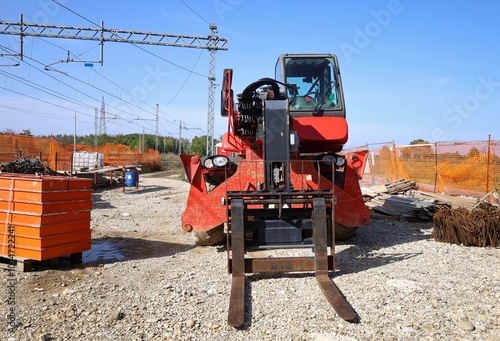 Rotating telehandler with forklift attachment during railroad  maintenance work. Front view.