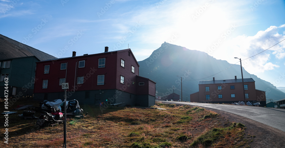 Fototapeta premium Exploring the scenic landscape of Longyearbyen with red buildings and majestic mountains