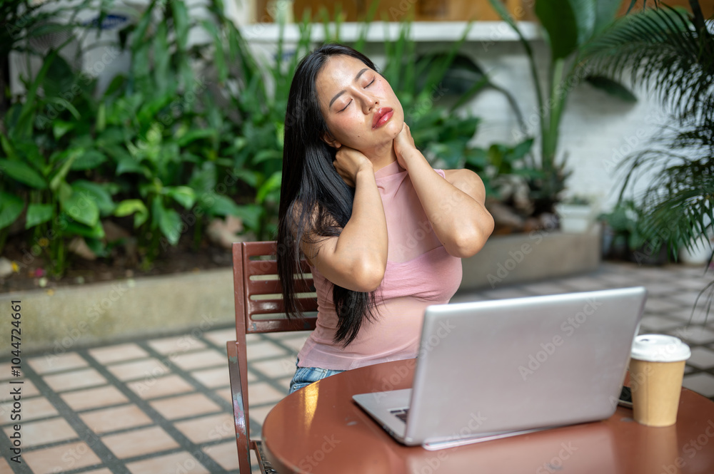 A woman is working remotely from a coffee shop, feeling tired and experiencing neck pain. A woman is working remotely from a coffee shop, feeling tired and experiencing neck pain.