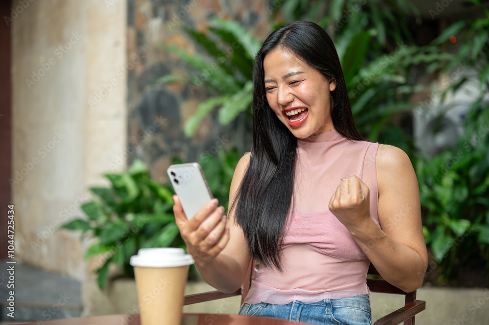A cheerful woman is receiving an unexpected message on her smartphone and celebrating her good news. A cheerful woman is receiving an unexpected message on her smartphone and celebrating her good news.