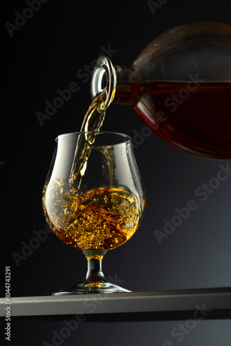 Cognac or brandy being poured into a glass. photo