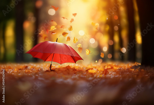 Wallpaper Mural A single red umbrella stands in a forest of golden leaves, with more leaves swirling around it, illuminated by a warm, golden light. Torontodigital.ca