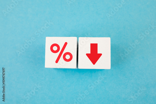 Cube block with percentage symbol. Concept of interest rate on financial and mortgage loans. Wooden cube with down arrow. Interest rate, stocks