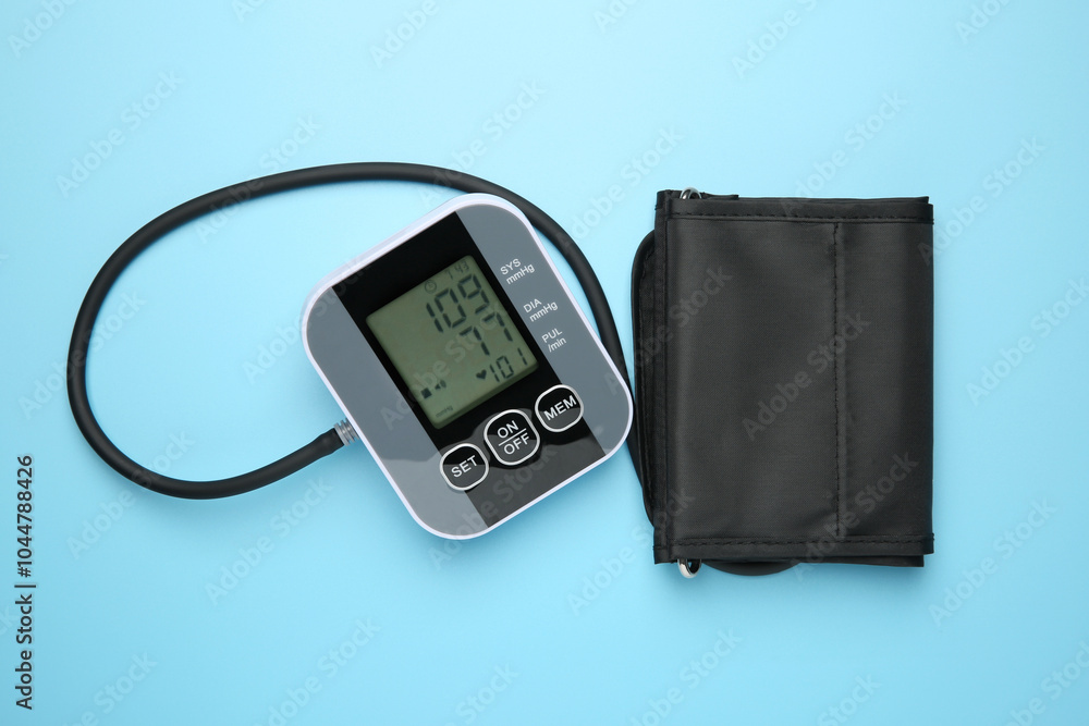 Blood pressure measuring device on light blue background, top view Blood pressure measuring device on light blue background, top view
