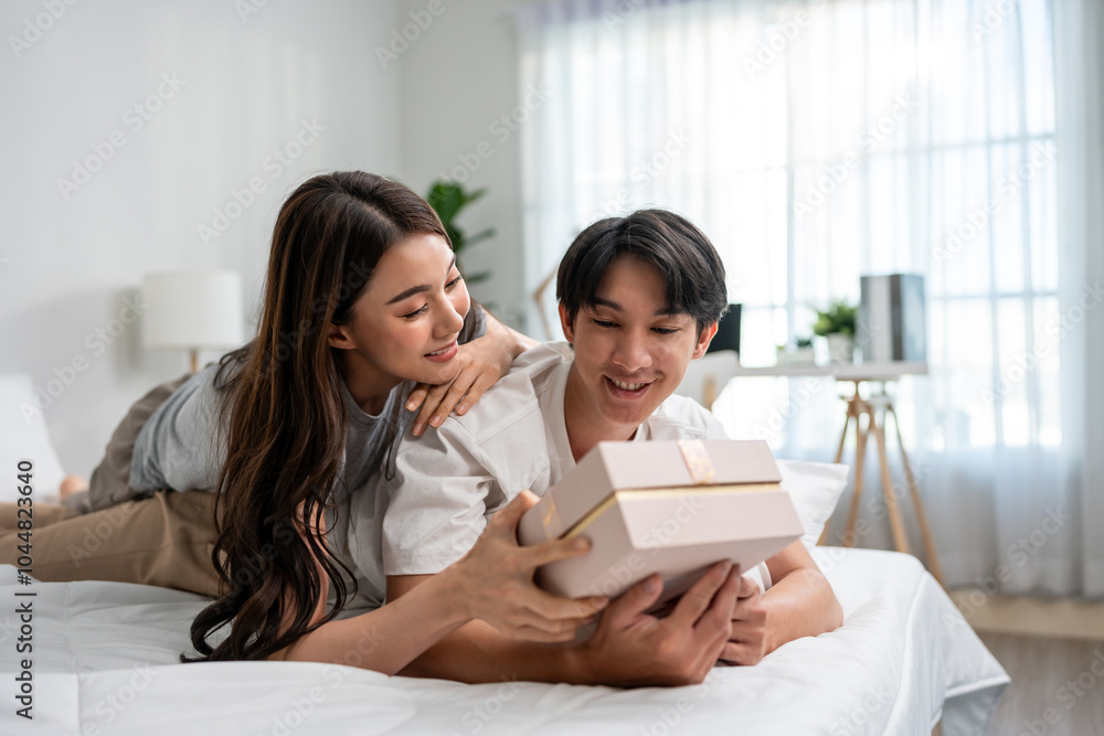 Asian handsome man receive birthday present gift box from girlfriend. Asian handsome man receive birthday present gift box from girlfriend.