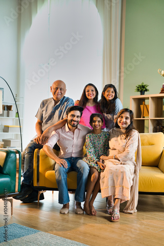 Photography Closeup of Indian family of six sitting together on a sofa in a lavish home, joy