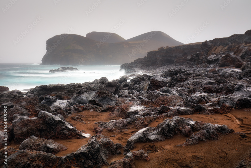 Obraz premium Rocky coast with lighthouse Farol da Ponta dos Capelinhos, Capelinhos peninsula, island of Faial, Azores, Portugal, Europe