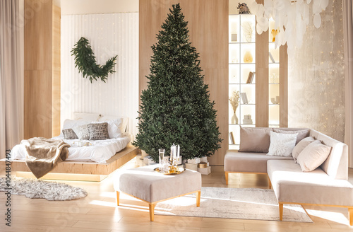 Beautifully decorated stylish designer living room scandinavia minimalism Christmas tree. Neutral tones furniture including a comfortable sofa and illuminated display create a warm atmosphere