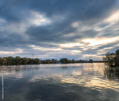 A calm lake with a cloudy sky in the background