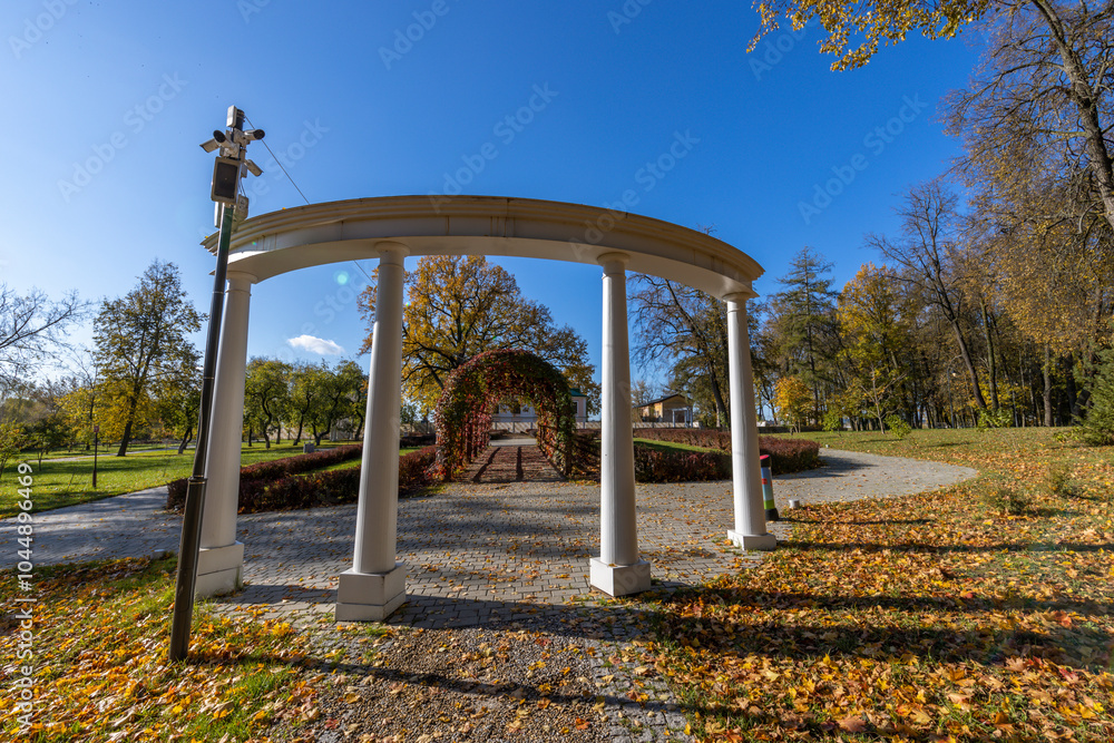 A large archway with white pillars and a cross on top