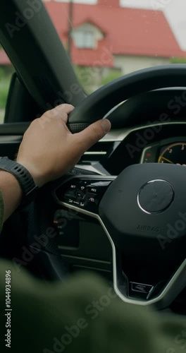 A man drives a car. Close-up of his hands on the steering wheel, an unrecognizable person. View from the car interior. Summer day