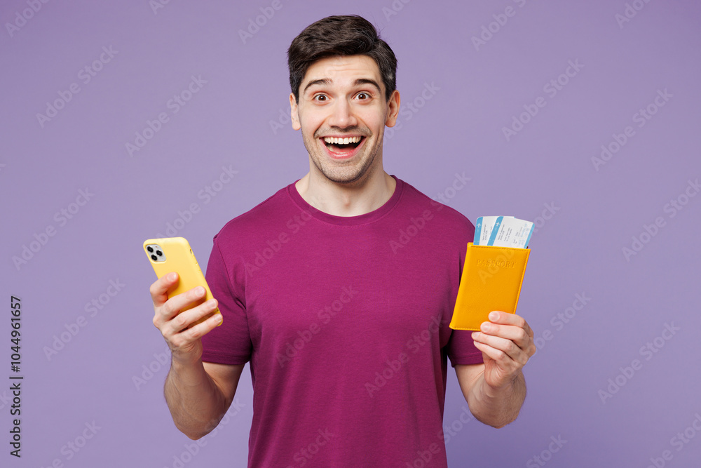 Traveler man wear casual clothes hold passport ticket use mobile cell phone isolated on plain pastel purple background. Tourist travel abroad in free time rest getaway Air flight trip journey concept Traveler man wear casual clothes hold passport ticket use mobile cell phone isolated on plain pastel purple background. Tourist travel abroad in free time rest getaway Air flight trip journey concept