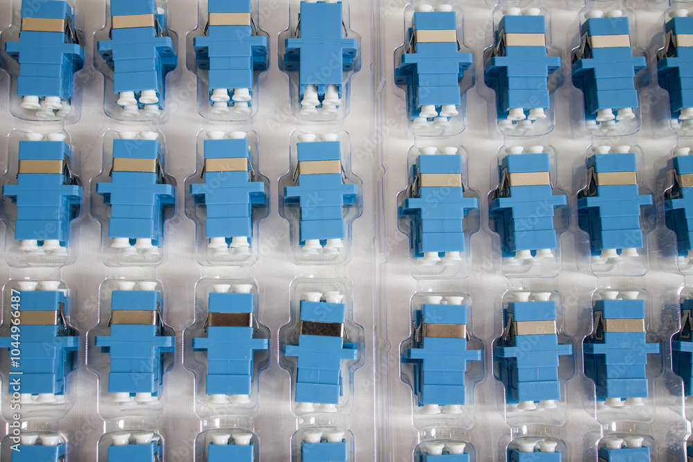 Obraz premium Optical adapters with different connectors in plastic blisters on the table, a batch of goods 