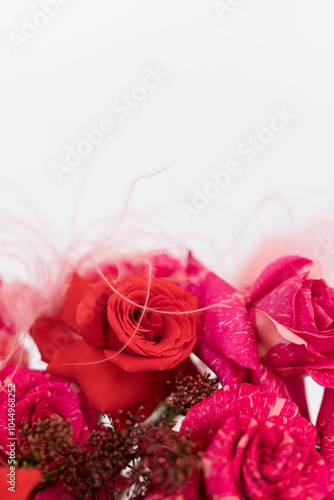 Delicate red and pink roses adorned with fine accents on a soft white background, perfect for celebrating love and nature's beauty
