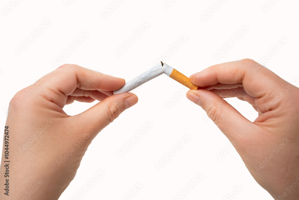 Close-up of a woman hands breaking a cigarette isolated on a white background Close-up of a woman hands breaking a cigarette isolated on a white background
