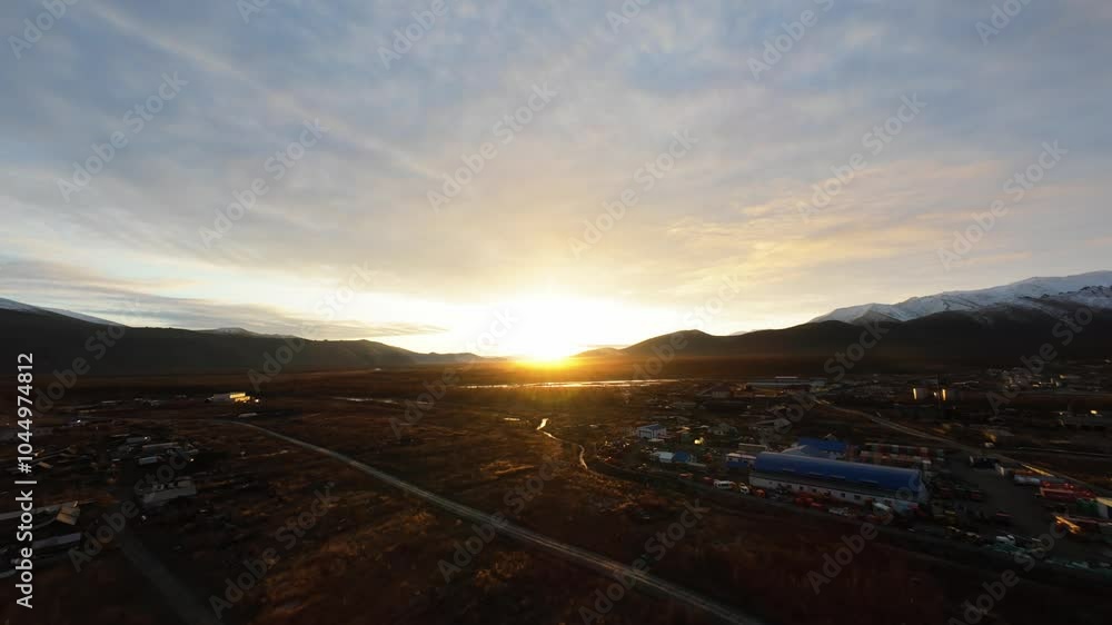 A stunning aerial view reveals the vibrant colors of sunset illuminating the vast wilderness of Yakutia. The serene landscape blends mountains and valleys as day turns to night. A stunning aerial view reveals the vibrant colors of sunset illuminating the vast wilderness of Yakutia. The serene landscape blends mountains and valleys as day turns to night.
