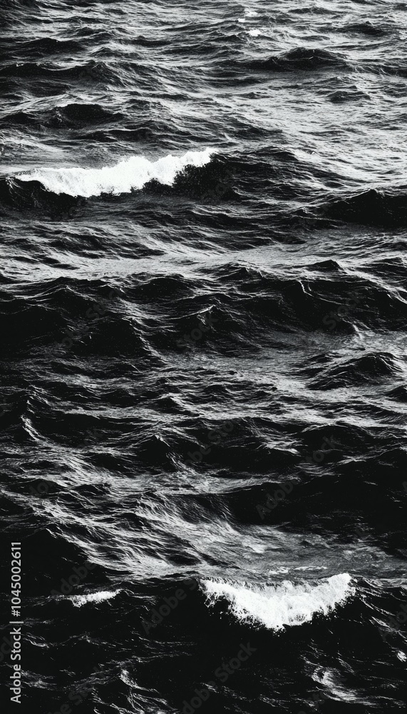 Naklejka premium Black and white image of ocean waves crashing, creating a dramatic and moody scene.