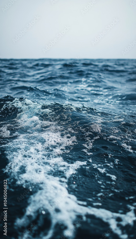 Fototapeta premium Close up view of ocean waves crashing and creating white foam.