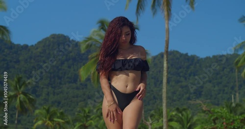 A girl in a bikini relishes the peaceful white sand beaches of a Caribbean island. photo