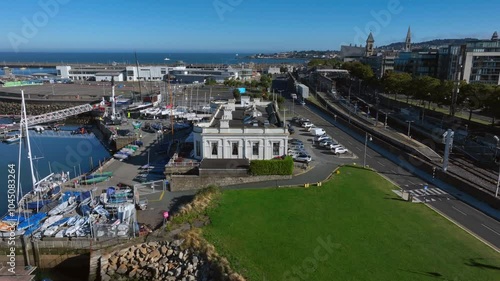 Royal Irish Yacht Club, Dún Laoghaire, County Dublin, Ireland, September 2024. Drone orbits counter clockwise above a lawn revealing the front facade of the building with the Marina behind. photo