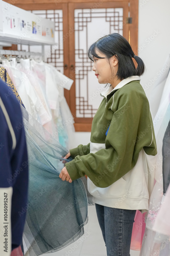 A Korean couple, a man in his 30s and a woman in her 20s, are harmoniously choosing clothes to wear at a hanbok rental shop in Seoul, South Korea. A Korean couple, a man in his 30s and a woman in her 20s, are harmoniously choosing clothes to wear at a hanbok rental shop in Seoul, South Korea.