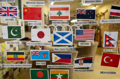 Many different national flags are displayed with a greeting in the corresponding language, translated as 'Welcome' at the entrance of a room in a multicultural childcare center in Australia. photo