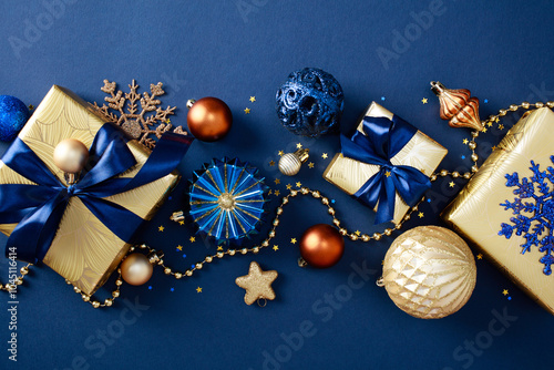 Elegant Christmas gifts, luxury decorations, glistening ornaments, garland on chic blue background. Merry Christmas and Happy New year greeting card design. Flat lay, top view.