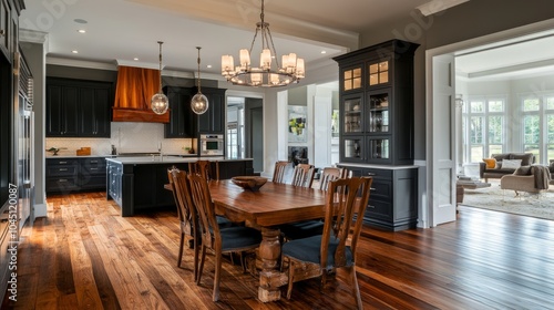 A stylish kitchen and dining room with classic design. The walls are a rich dark gray, and the floors are warm wood.