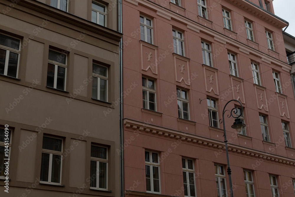 Naklejka premium There stands a prominent building with numerous windows, and just in front of it, there is a street light illuminating the area