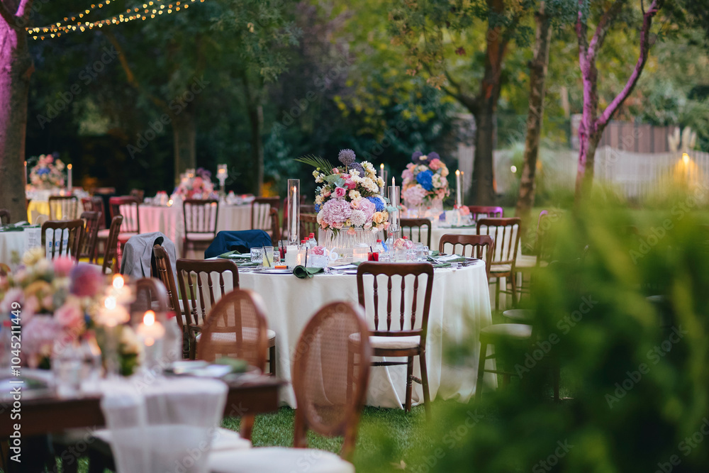 Outdoor Wedding Reception with Floral Centerpieces and Elegant Table Setting - A Romantic Garden Event
