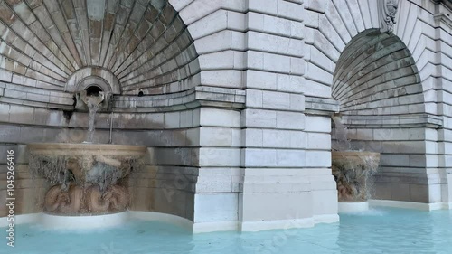 Fountain in Louise Michel square (place) on top of Montmartre hill next to the Basilica of Sacre Coeur. Running water stream, fountain. Paris, France photo