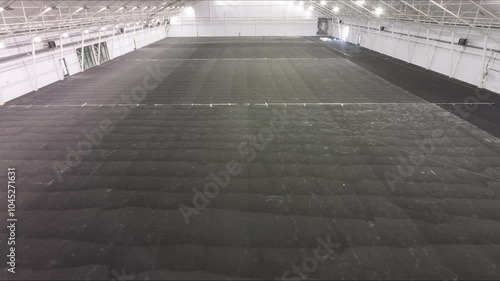 A time-lapse video showcasing the construction of indoor tennis courts. The process includes surface installation and floor painting, capturing key stages of the project. 