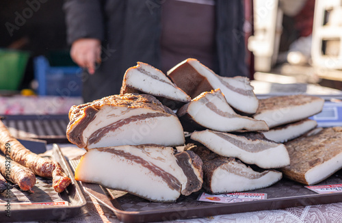 Selective blur on blocks of slanina, a serbian bacon, made of dried cured pork, smoked, on the stand of a countryside market of Serbia. It's a traditional meat product from Balkans. photo