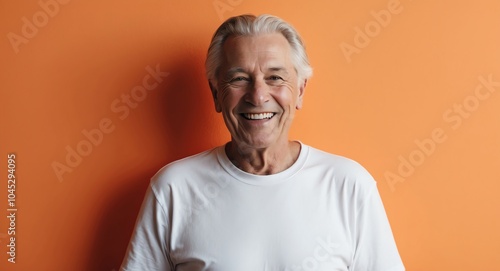 redhead elderly man orange background wearing plain white tshirt smiling happy portrait