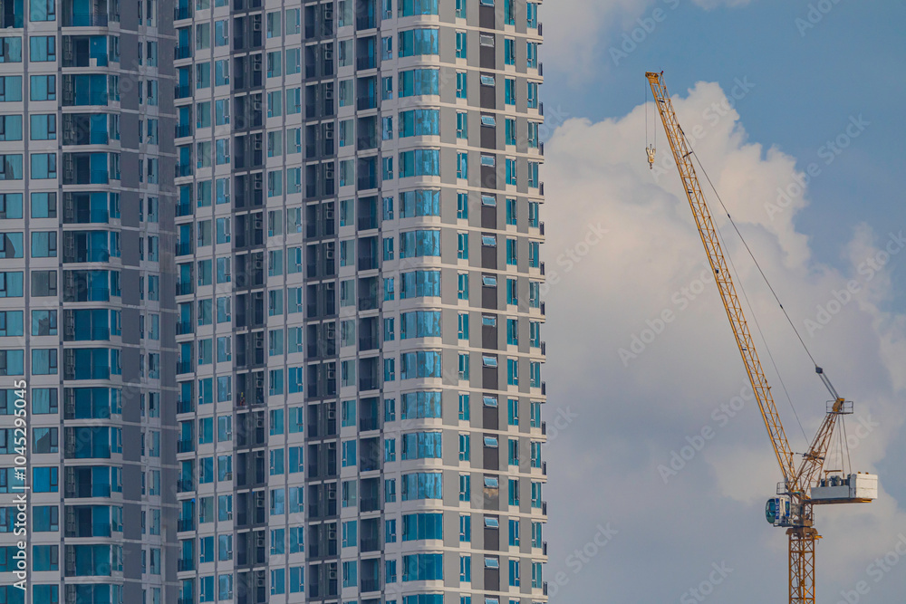 A construction crane builds a tall downtown apartment A construction crane builds a tall downtown apartment