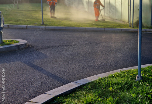 highway maintenance workers manually cut an exit or road intersection. sunrise and fog hard work in reflective clothing photo