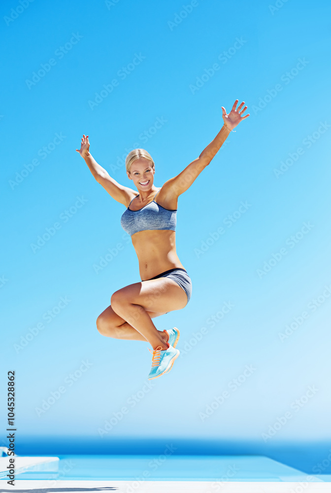 Excited woman, portrait and winning with jump for fitness, celebration or exercise goals on patio. Young, female person or active athlete with smile in joy for workout, challenge or training success Excited woman, portrait and winning with jump for fitness, celebration or exercise goals on patio. Young, female person or active athlete with smile in joy for workout, challenge or training success