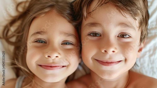 A close-up portrait of two siblings with curly hair , smiling softly while lying side by side. Their relaxed expressions and gentle features highlight a peaceful bond