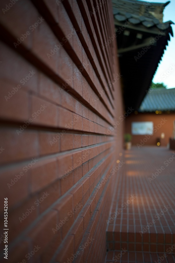 Fototapeta premium Side shot of Red brick wall of a traditional pagoda showcasing intricate architectural design