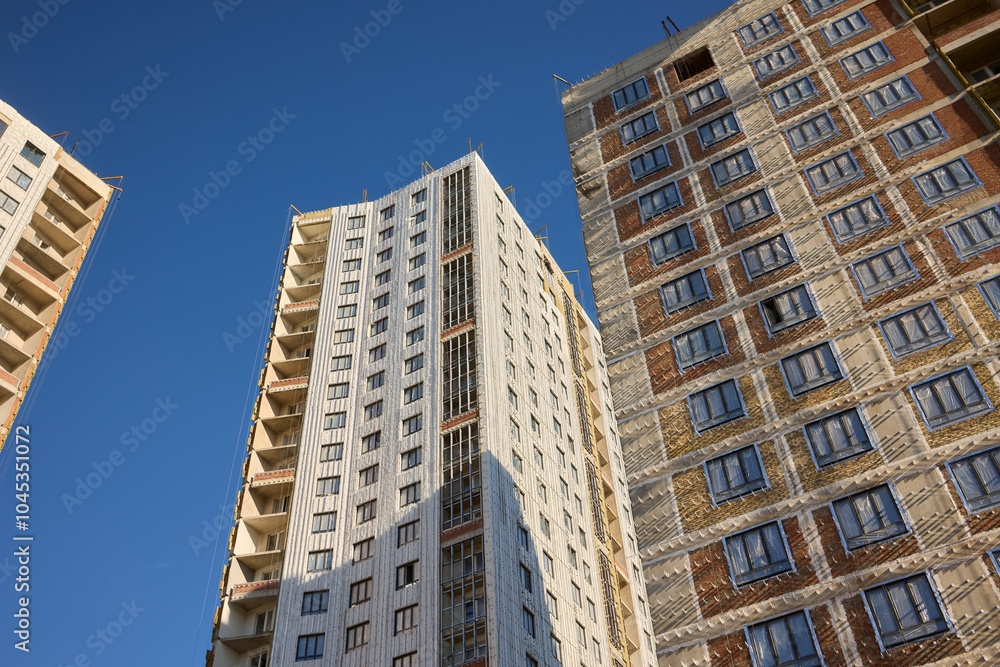 The modern architectural facade stands strikingly under a bright, clear blue sky above it The modern architectural facade stands strikingly under a bright, clear blue sky above it