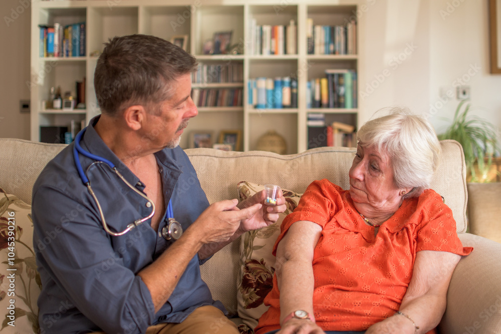 Obraz premium Doctor administering meds, pills to a senior lady at home. Explaining adverse affects of the drugs and correct dosage. Hospice, homecare.
