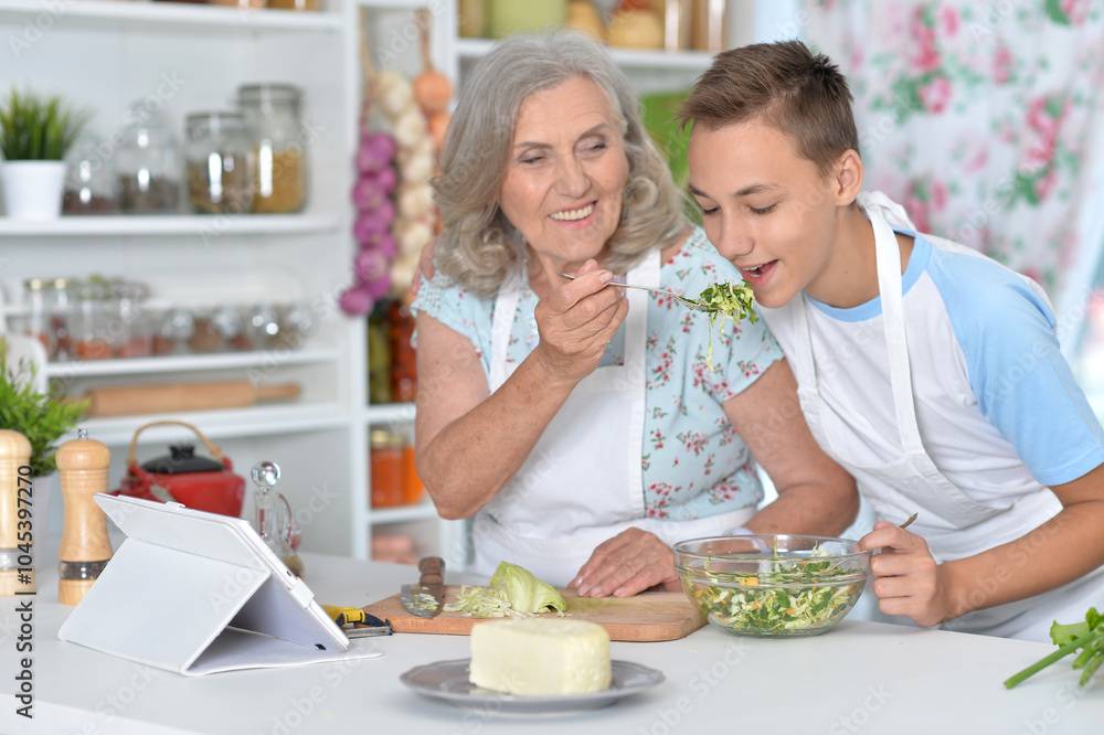 A young boy with his grandmother cooking in the kitchen A young boy with his grandmother cooking in the kitchen